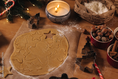 Christmas bakery of gingerbread, cutting cookies of gingerbread dough. Christmas and New Year traditions concept. Candle light