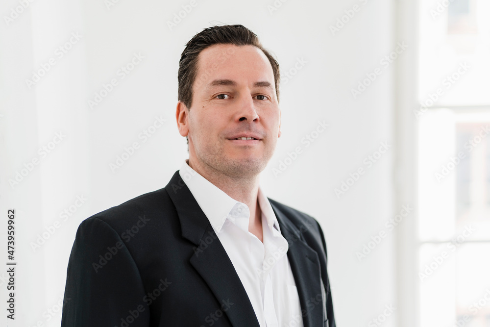 Confident businessman in black blazer at office Confident businessman in black blazer at office