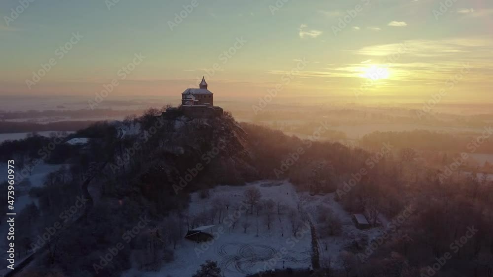 Aerial, early morning view of the Castle standing on the hill above fog at sunrise, light by morning sun rays. Aerial, early morning view of the Castle standing on the hill above fog at sunrise, light by morning sun rays.