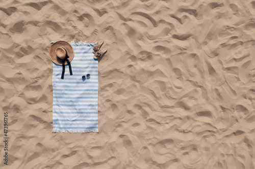 Fototapeta Naklejka Na Ścianę i Meble -  Towel with beach accessories on sand, top view. Space for text
