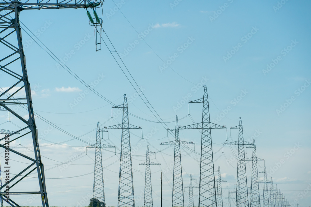 Support of an overhead power line. Transmission of electricity from a powerful power plant to the city. Poles with wires on the background of a beautiful sky.