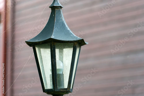 Decorative small garden lamp, Lanterns on a flower bed and in a green garden. Garden design. A small lantern gives coziness and comfort in the yard of the house.