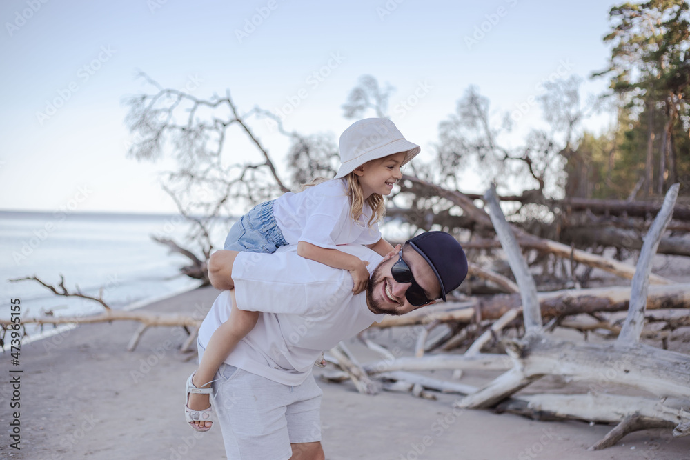 Daddy carrying daughter on his back at the beach. Daddy carrying daughter on his back at the beach.