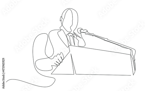 A man in a suit giving a speech on the podium.