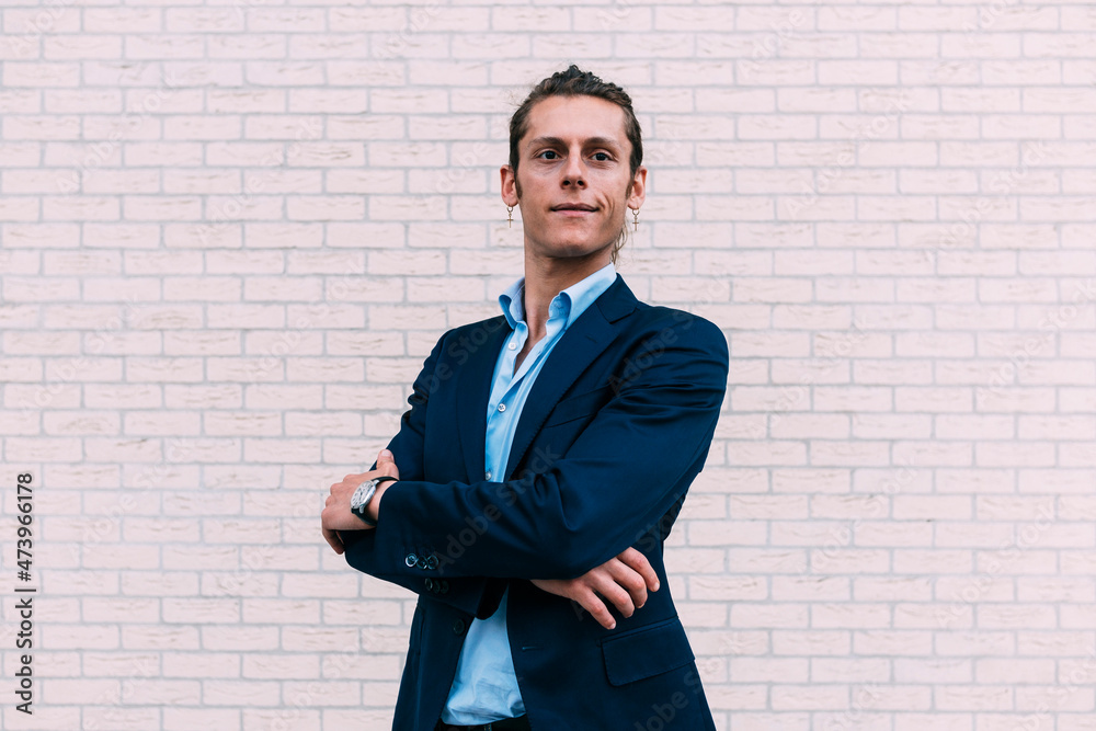 Smiling businessman with arms crossed standing in front of wall Smiling businessman with arms crossed standing in front of wall
