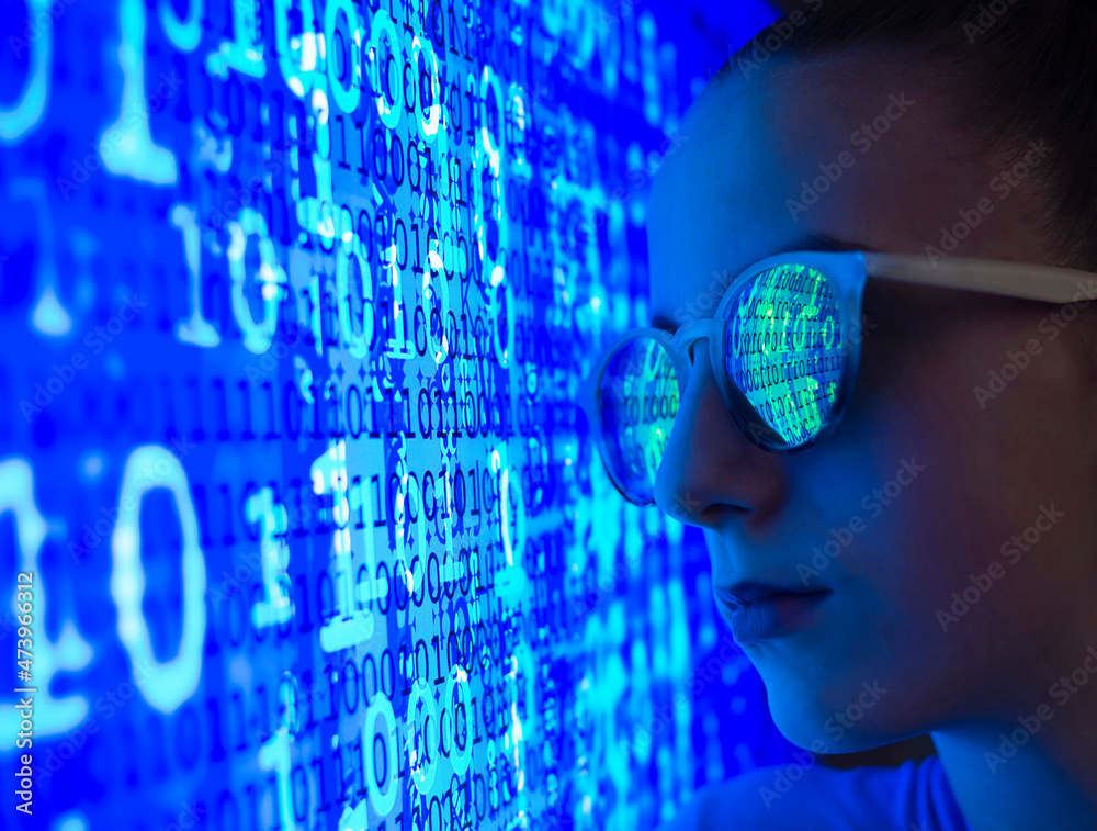 © Westend61 - Female computer hacker with binary code reflection on eyeglasses
