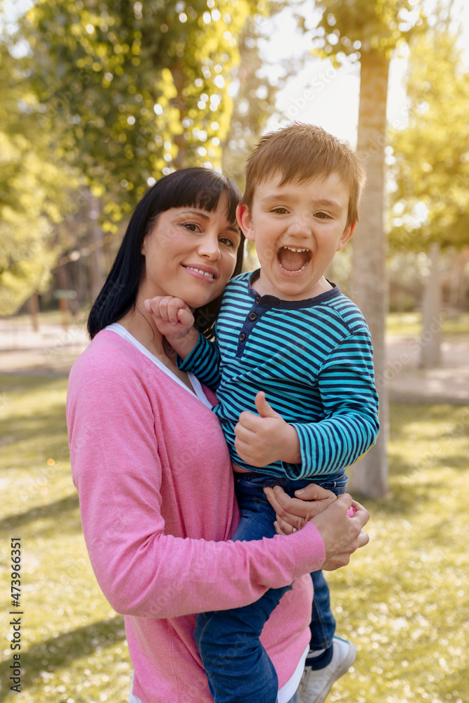 Mother carrying cheerful son at public park Mother carrying cheerful son at public park