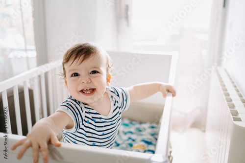 Happy baby boy in crib at home