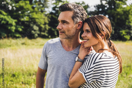 Thoughtful couple standing together at meadow