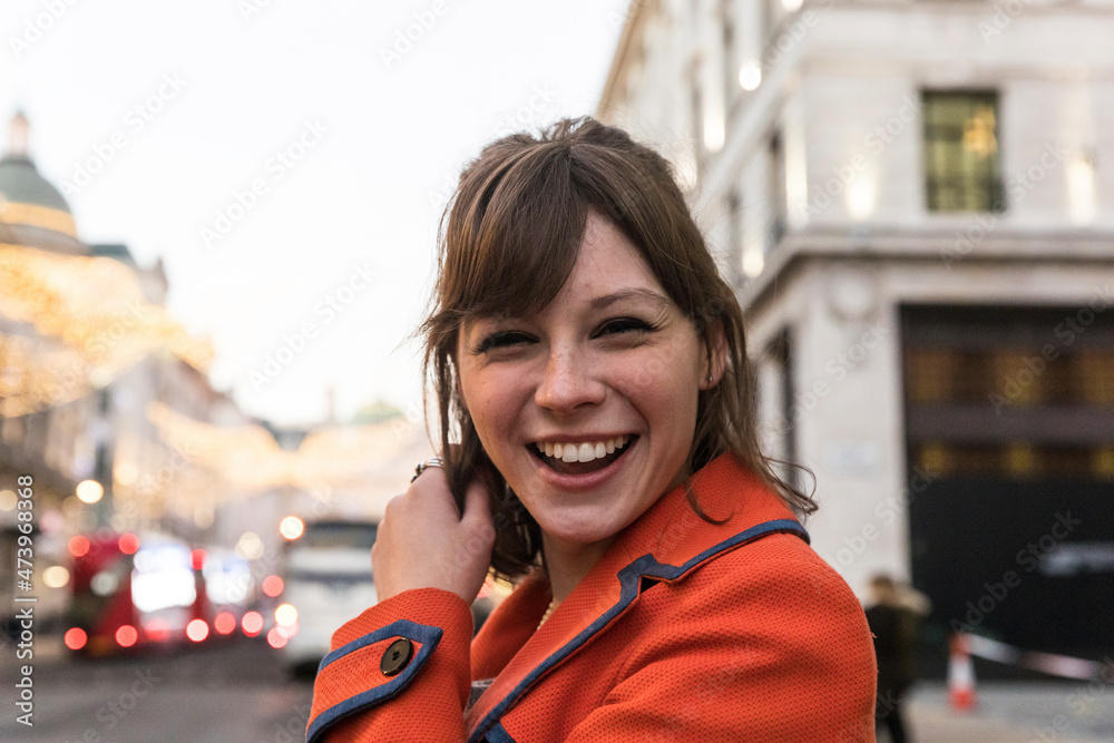 Cheerful young woman with brown hair standing in city Cheerful young woman with brown hair standing in city