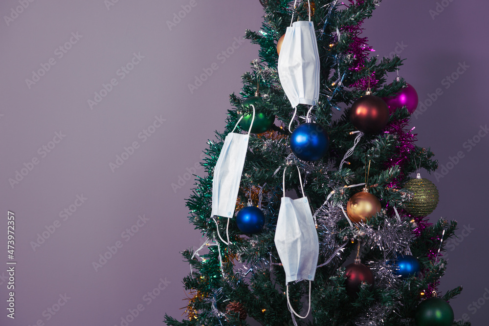 Christmas tree with decoration and face masks as a symbol of coronavirus