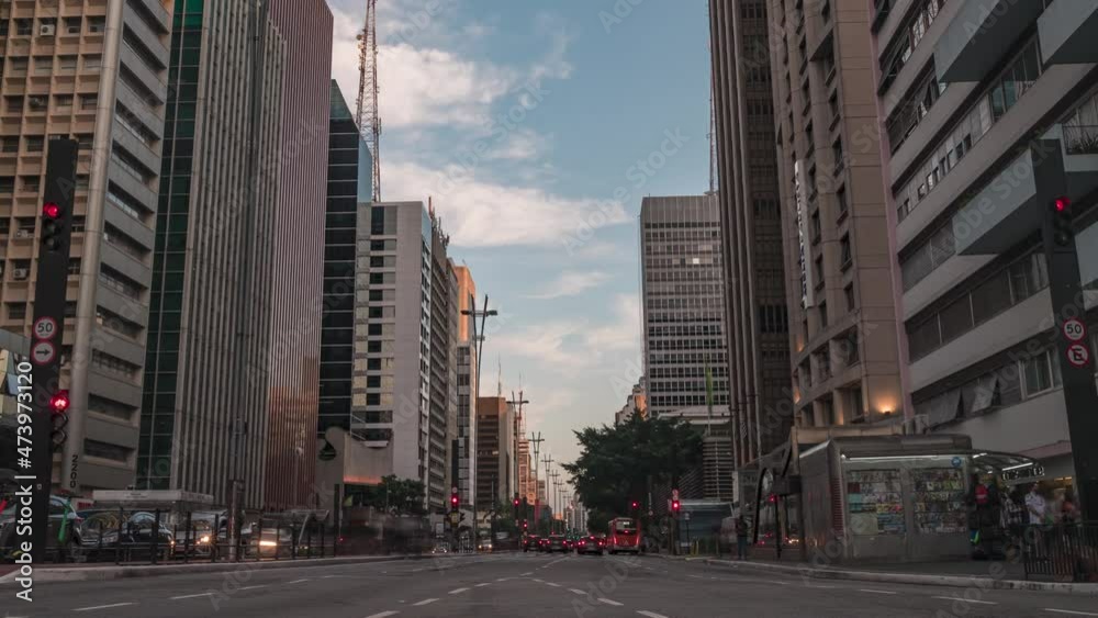 motion timelapse da avenida Paulista em São Paulo, durante um por do sol lindo, sunset com poucas nuvens e muito trânsito zoom out
