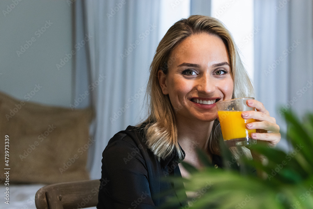Smiling female professional holding juice glass at home Smiling female professional holding juice glass at home