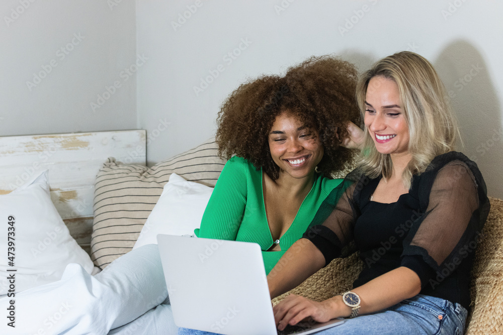 Smiling female friends using laptop at home Smiling female friends using laptop at home