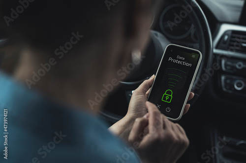 Woman unlocking data protection lock on smart phone in car