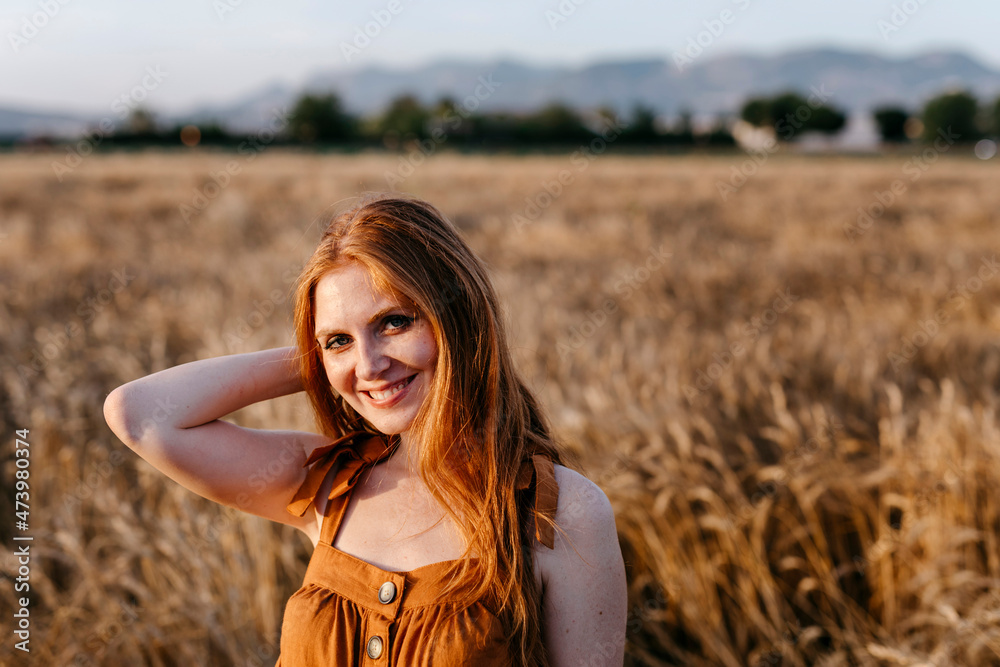 Smiling redhead woman in agricultural field Smiling redhead woman in agricultural field