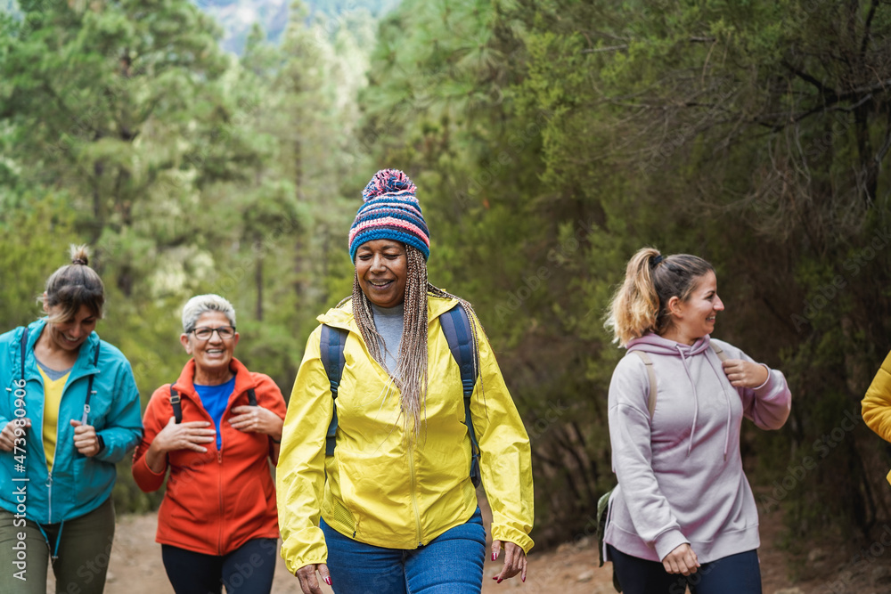 Multiracial women having fun during trekking day in to the wood - Focus on african female face Multiracial women having fun during trekking day in to the wood - Focus on african female face