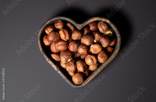 peeled hazelnuts in a heart-shaped plate © IrinaSo
