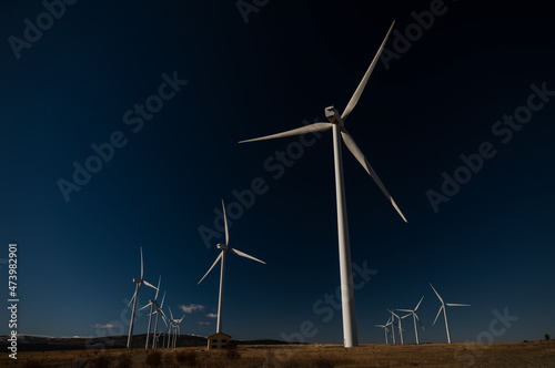 Modern windmills in land against blue sky. Shot in Castilla La Mancha, Spain © WeeKwong