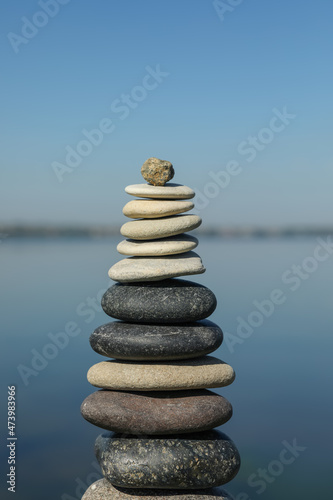 Stack of stones near sea on sunny day. Harmony and balance concept