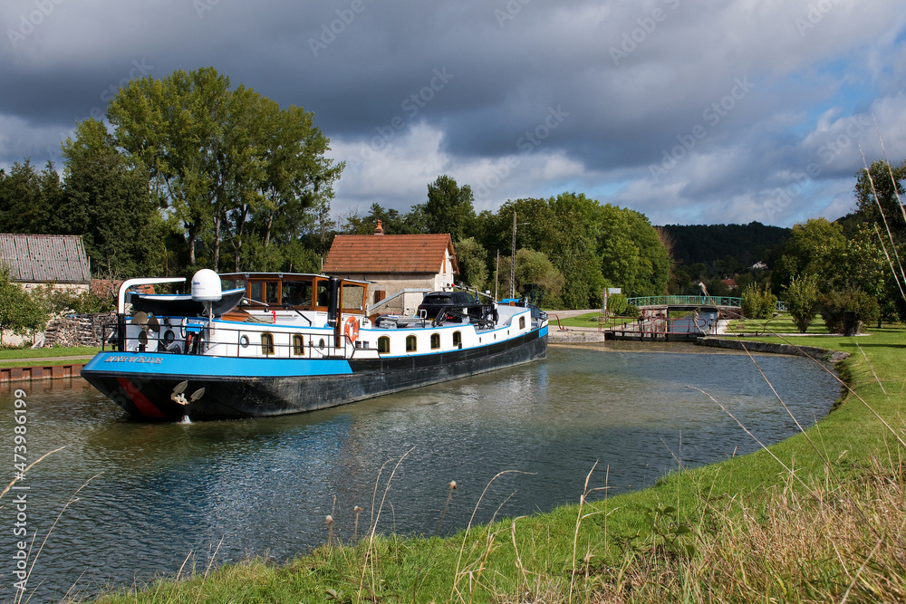 Fototapeta premium Schleuse mit Peniche, Boot auf dem Canal-de-Bourgogne in Ancy-le-Libre, Panoramablick