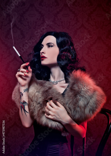 Retro burlesque diva with tattoes smoking a cigarette.