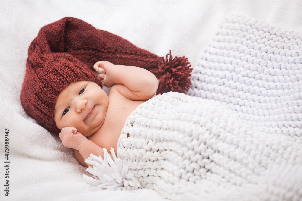 Cute newborn baby girl in a knitted hat on the white backdround Cute newborn baby girl in a knitted hat on the white backdround