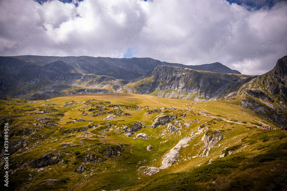 Bulgarian landscape of a mountain peak in Rila mountain.Beautiful nature landscape.Green grass and blue sky with clouds. High quality photo