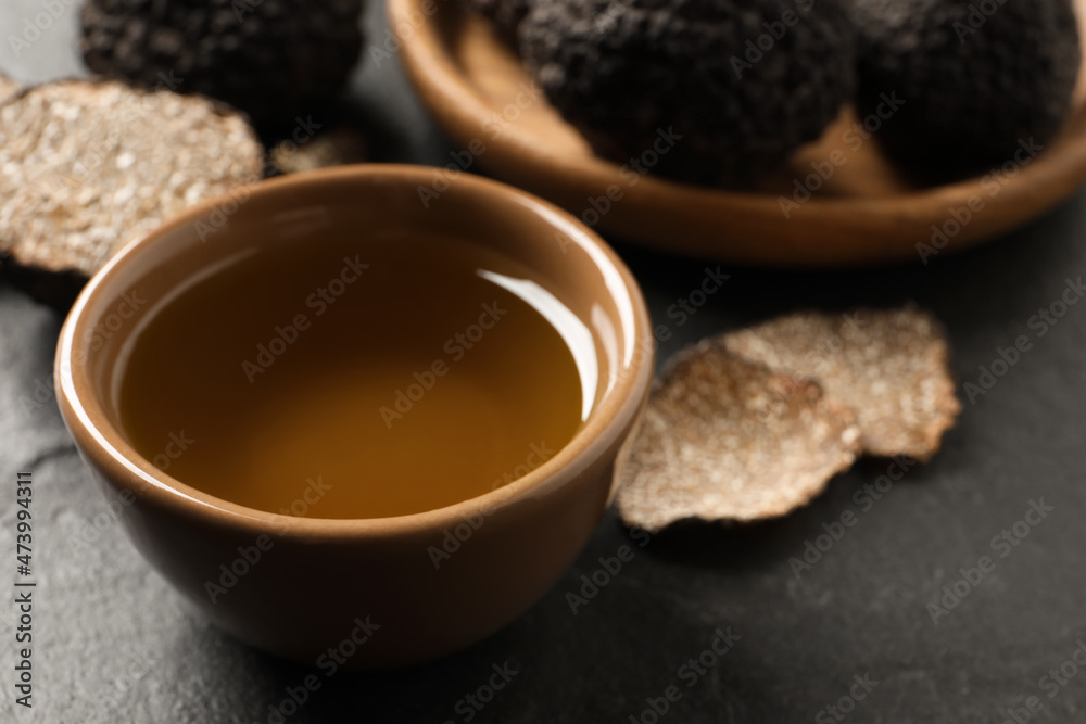 Bowl of truffle oil on grey table, closeup Bowl of truffle oil on grey table, closeup