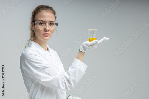 Chemical test tubes and flasks with petroleum products, the girl is a laboratory assistant, safety glasses