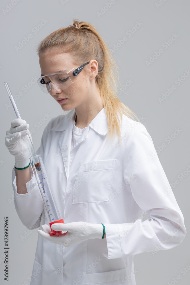 Chemical test tubes and flasks with petroleum products, the girl is a laboratory assistant, safety glasses. white gloves. measuring cylinder, hydrometer Chemical test tubes and flasks with petroleum products, the girl is a laboratory assistant, safety glasses. white gloves. measuring cylinder, hydrometer