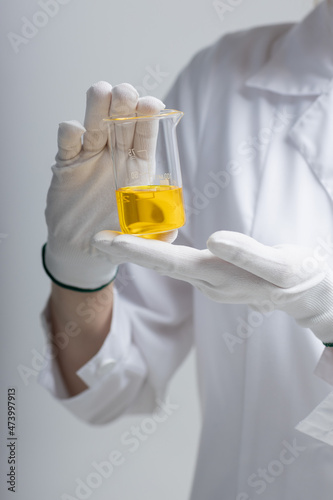 Chemical test tubes and flasks with petroleum products, safety glasses white gloves