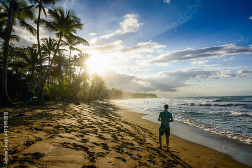 Rear view of man walking at beach against sky during sunset, Playa Bonita, Las Terrenas, Dominican Republic photo