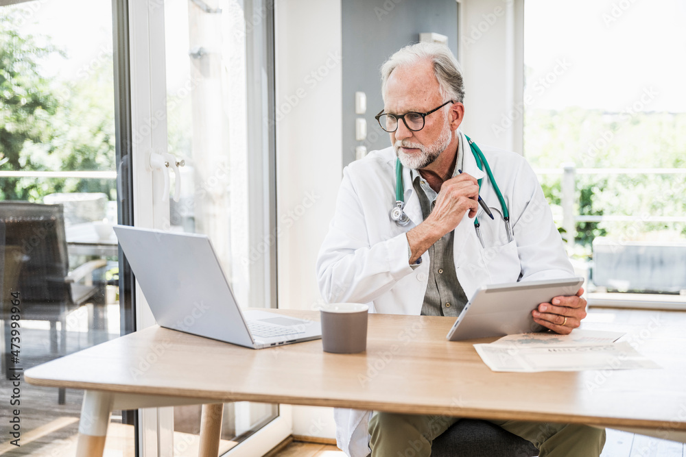 Male doctor using wireless technologies at desk Male doctor using wireless technologies at desk