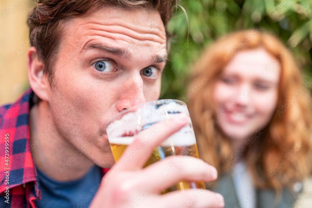 Man with raised eyebrows drinking beer at pub Man with raised eyebrows drinking beer at pub
