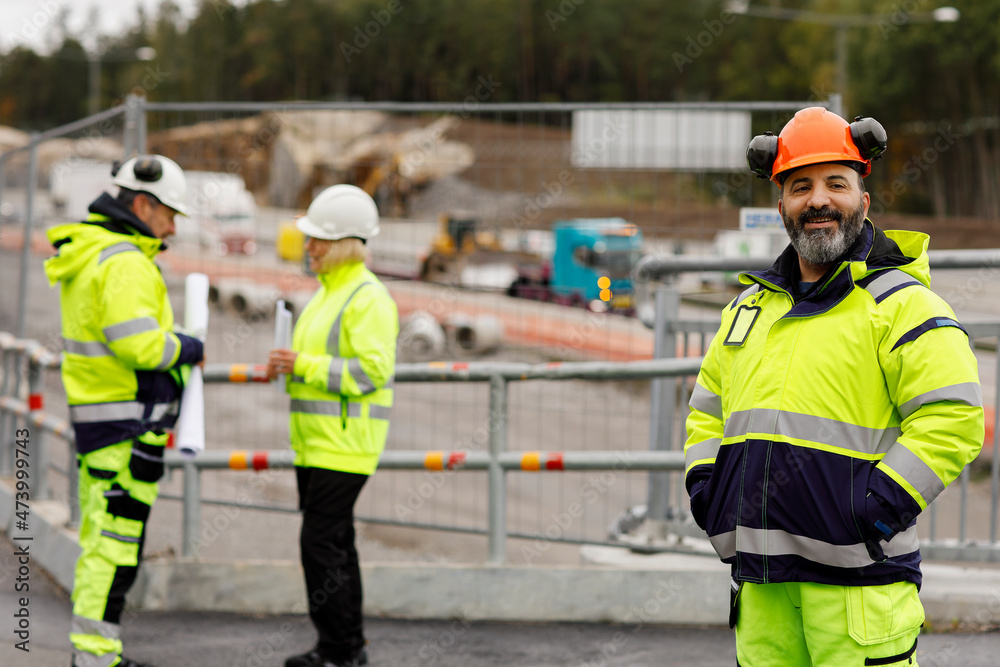 Engineers in reflecting clothing at building site Engineers in reflecting clothing at building site