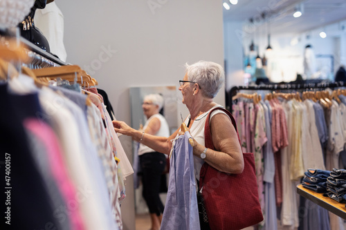 Senior woman doing shopping in clothes shop photo