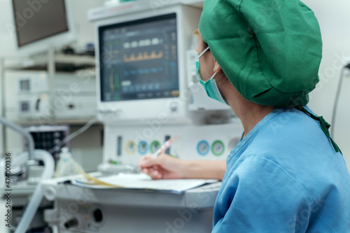 Anesthetist working control anesthetic and unconscious with computer monitor in surgery procedure at operating room. photo