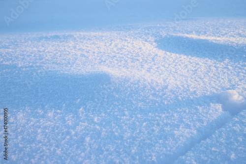 Close-up of a snowdrift. Snow lies beautifully on the ground. Blue snow dunes. Winter nature background, texture 