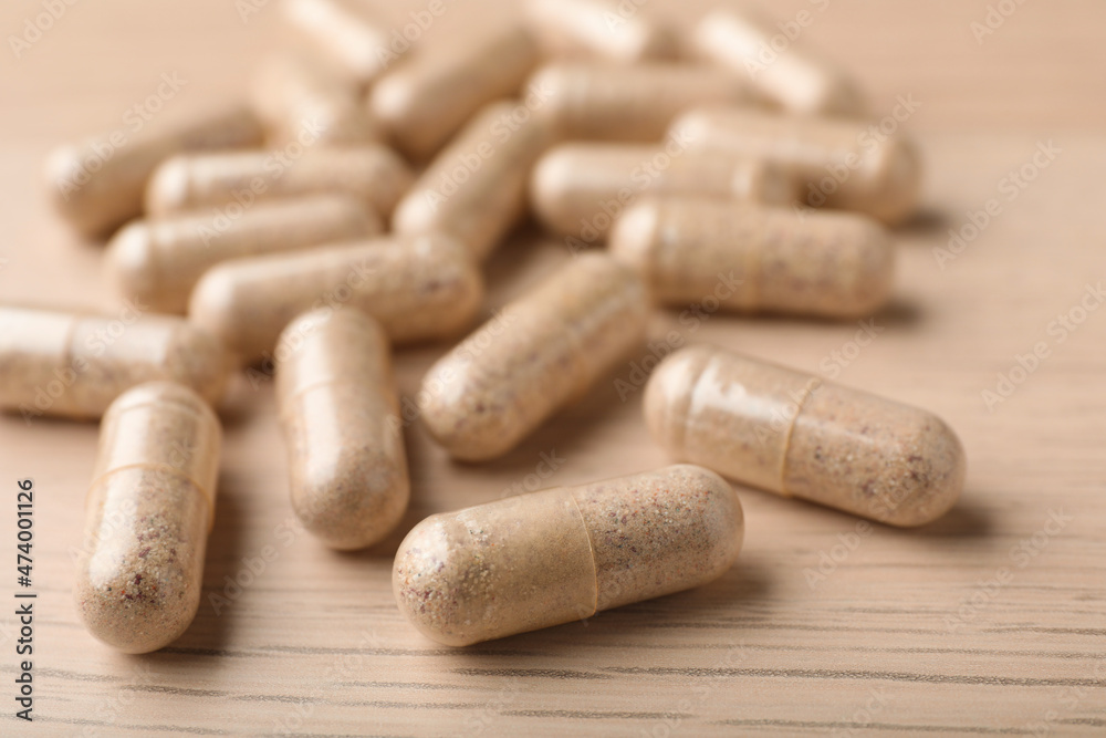Gelatin capsules on wooden table, closeup view Gelatin capsules on wooden table, closeup view