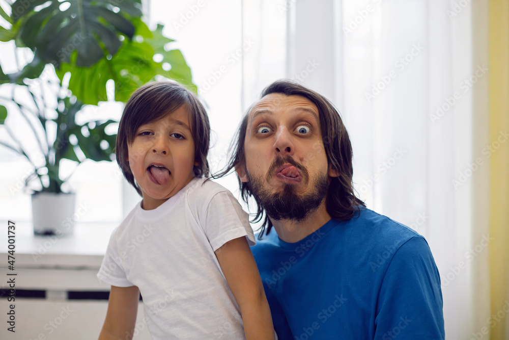 © saulich84 - father in a blue T-shirt and a son in a white T-shirt are sitting on the windowsill large window