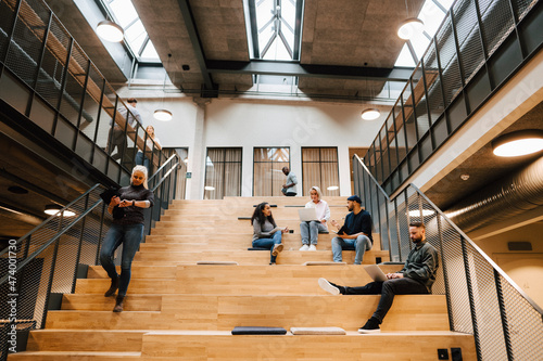 People relaxing on stairs in office building photo