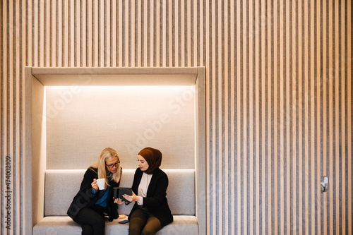 Female coworkers talking together photo