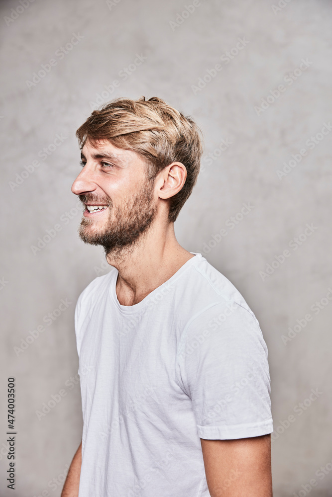 Handsome man smiling while looking away by wall Handsome man smiling while looking away by wall