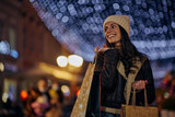 Smiling female shopper outside in city in evening