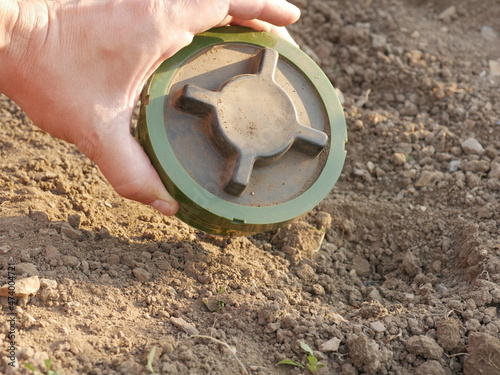 PMN-2 soviet anti-personnel mine buried in a man's hand 
