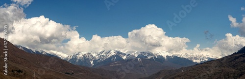 Panoramic view of snow capped mountains in the clouds. Caucasian mountains. Sochi Krasnaya Polyana. Russia.