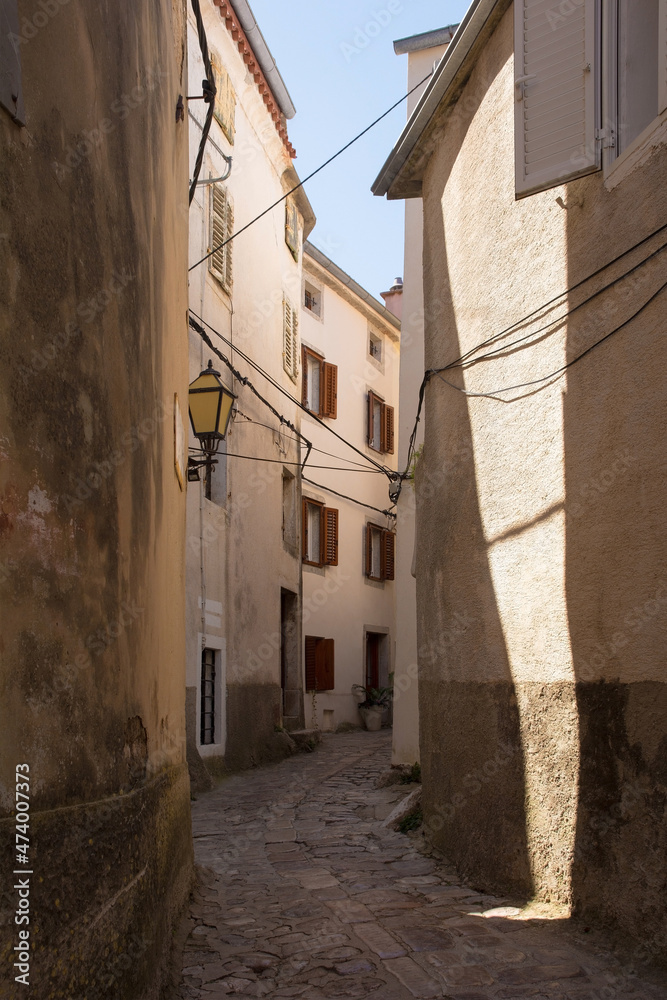 A quiet residential street in the historic medieval centre of Vrbnsk hill village on Krk Island in the Primorje-Gorski Kotar County of western Croatia
