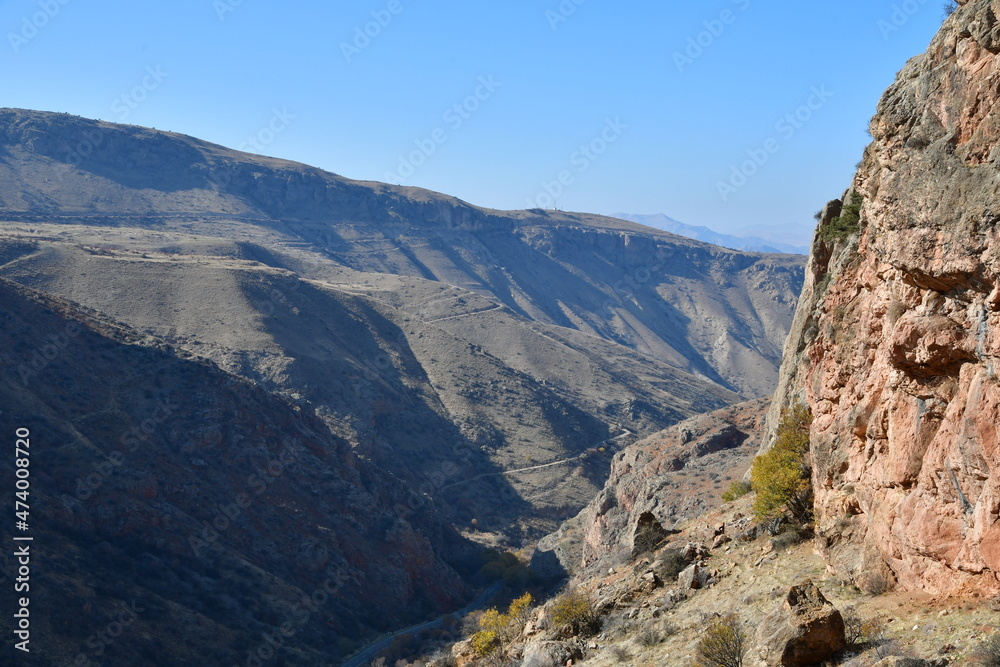 Panoramic view of the mountains on a sunny day. View of sheer cliffs and a stream in the gorge. Panoramic view of the mountains on a sunny day. View of sheer cliffs and a stream in the gorge.