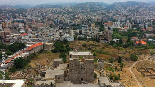 Aerial Panning Tourists Exploring Built Structure In City, Drone Flying Over Landscape - Byblos, Lebanon photo